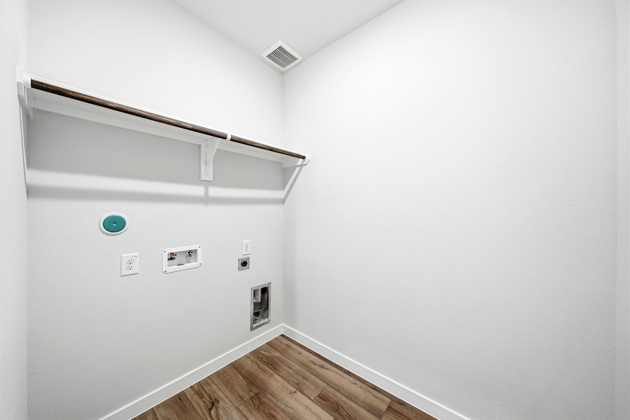 A white wall with a wood floor.