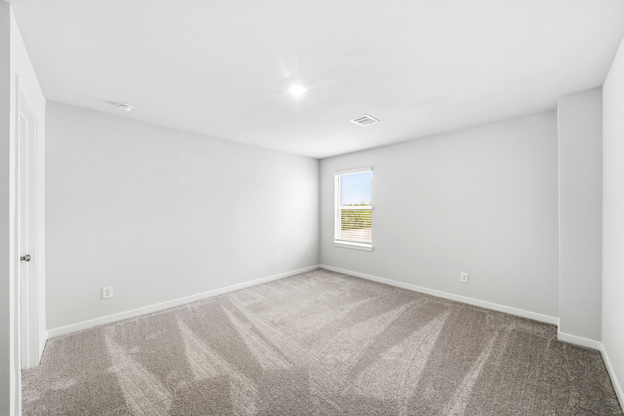 A room with a carpet and a window.