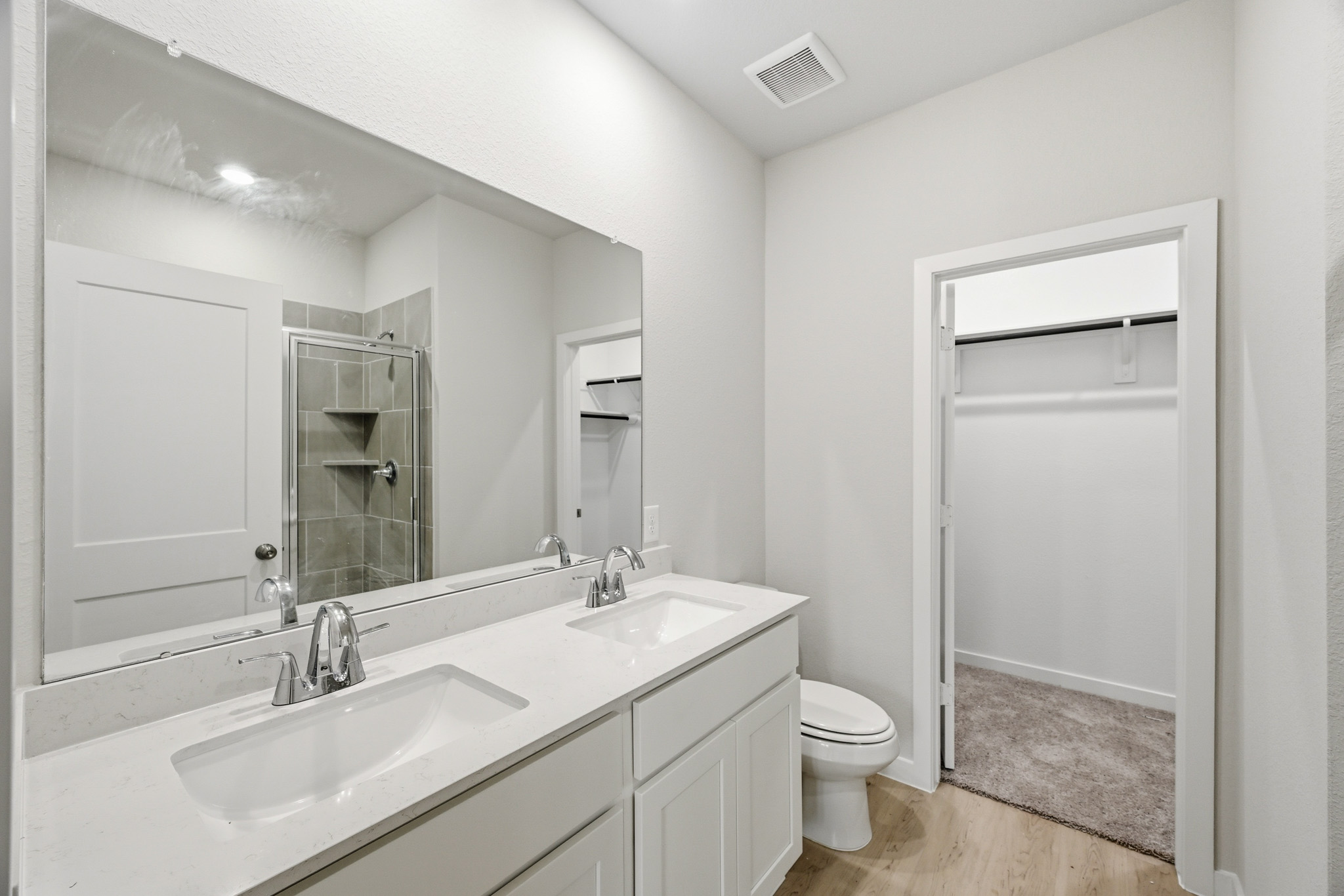 A bathroom with a sink toilet and mirror.