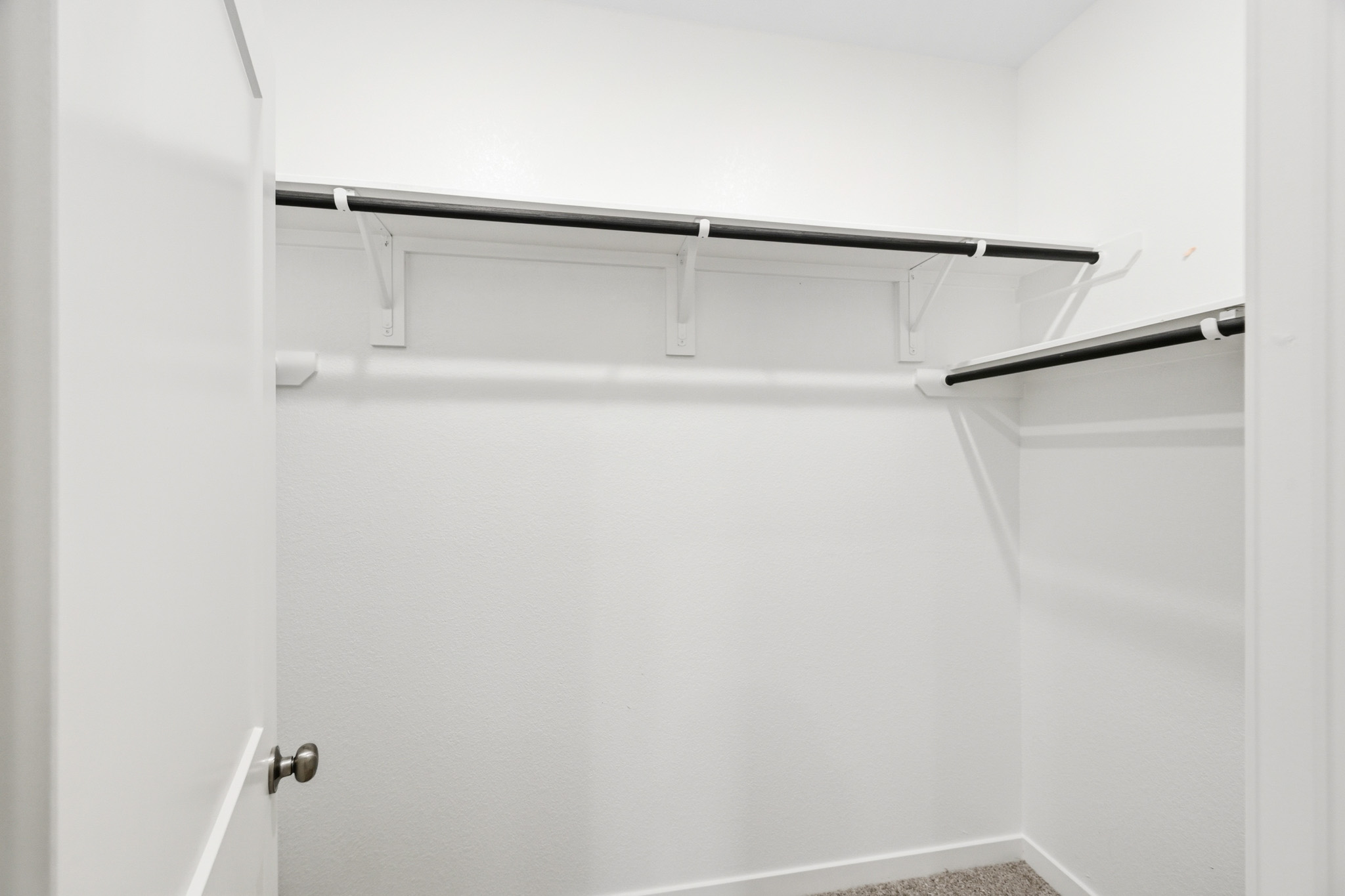 A white door with a metal bar.