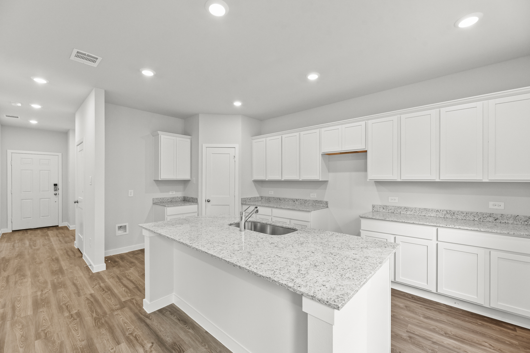 A kitchen with white cabinets.
