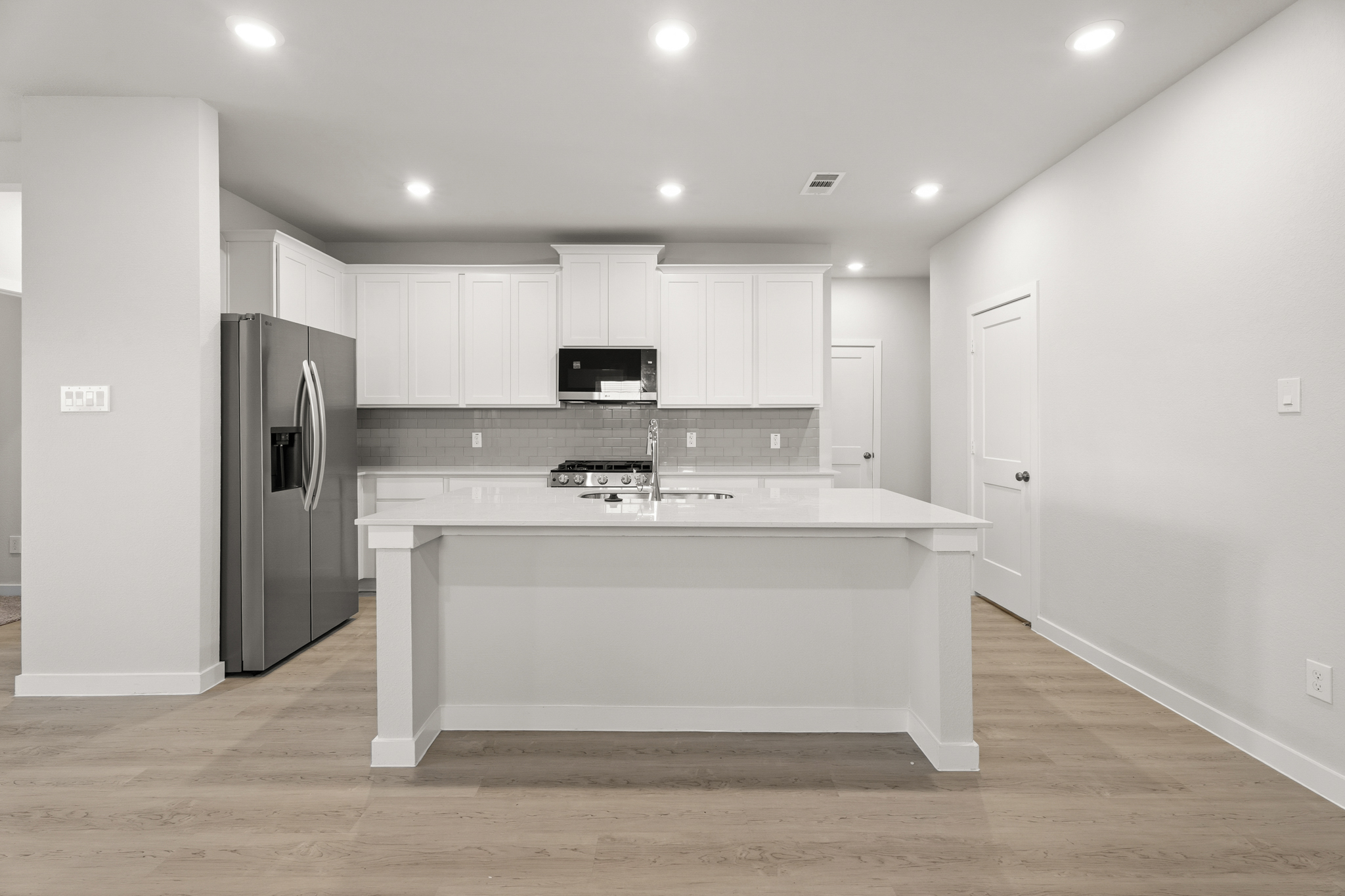 A kitchen with white cabinets.