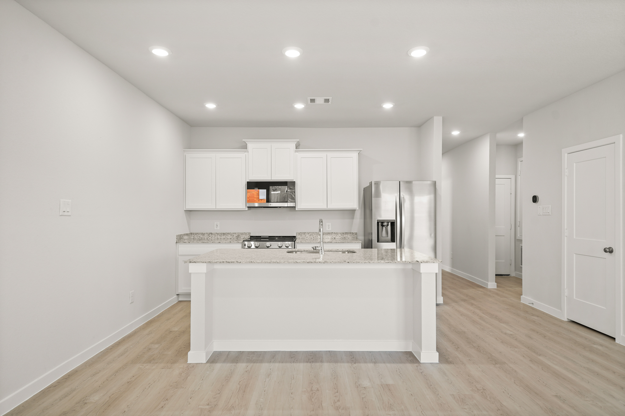 A kitchen with white cabinets.