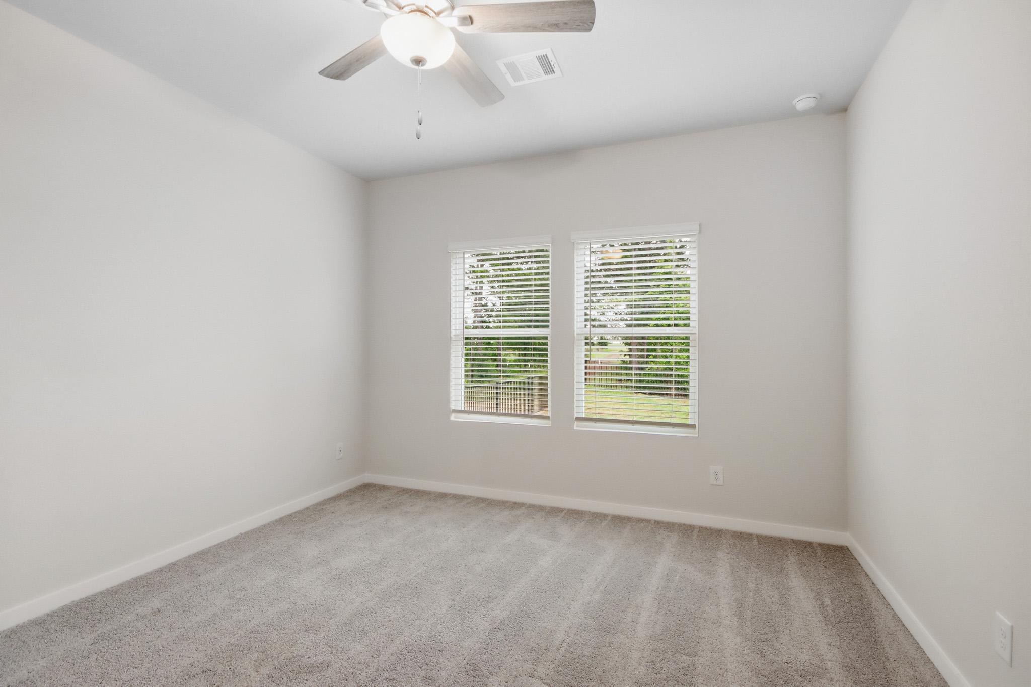 A room with a ceiling fan and a window.