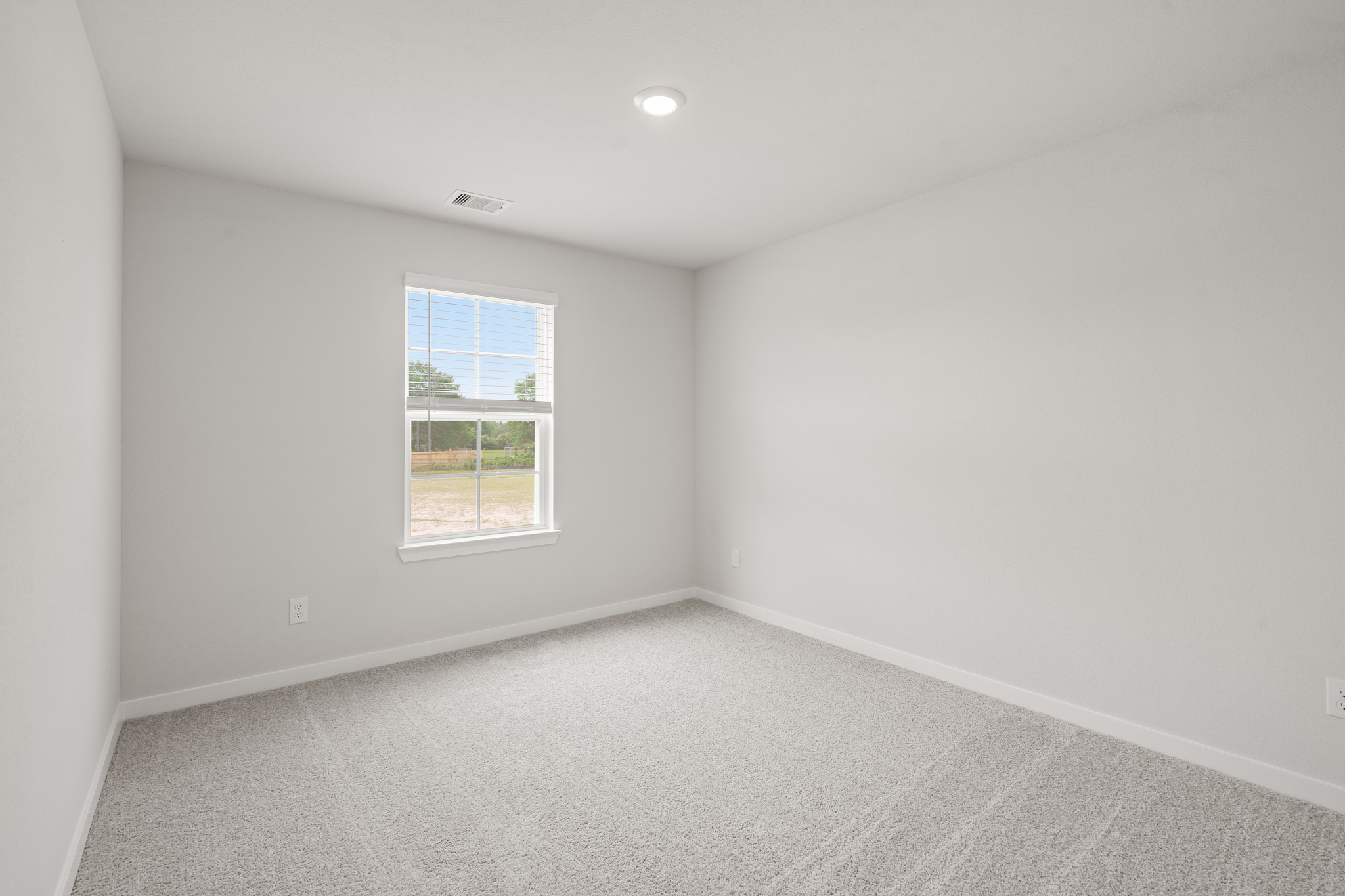 A room with a window and a carpet.