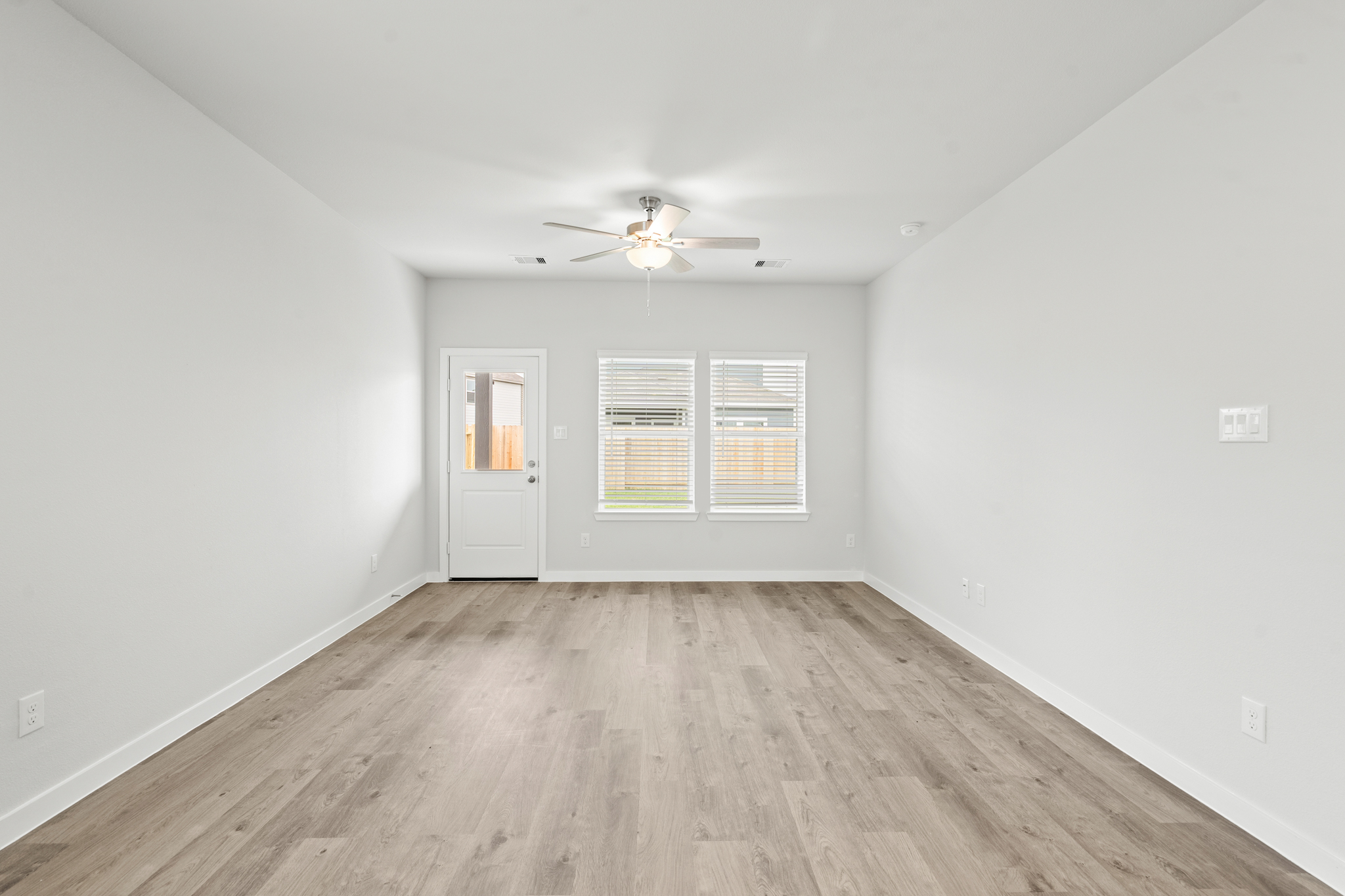 A room with a wood floor and a ceiling fan.