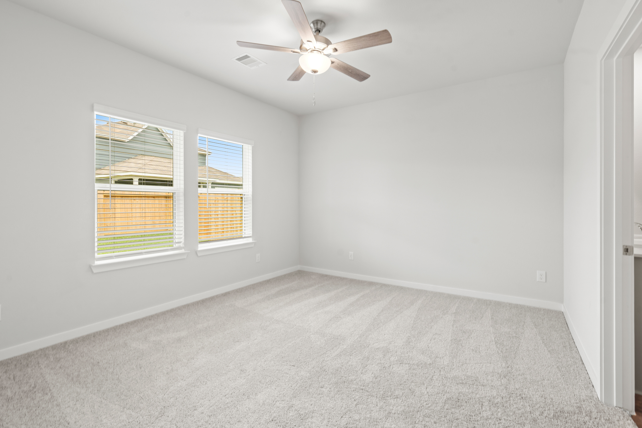 A room with a ceiling fan and a window.