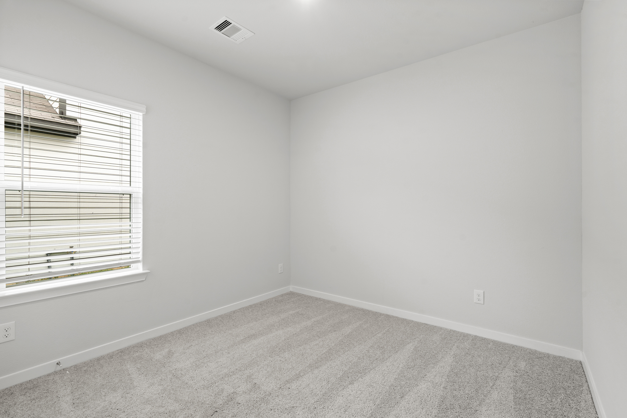 A room with a window and a carpet.