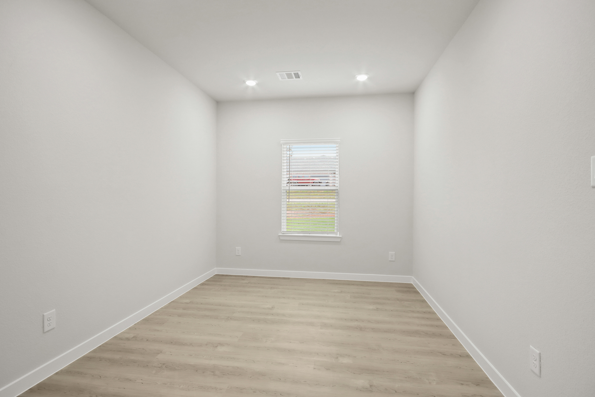 A room with a wood floor and a window.