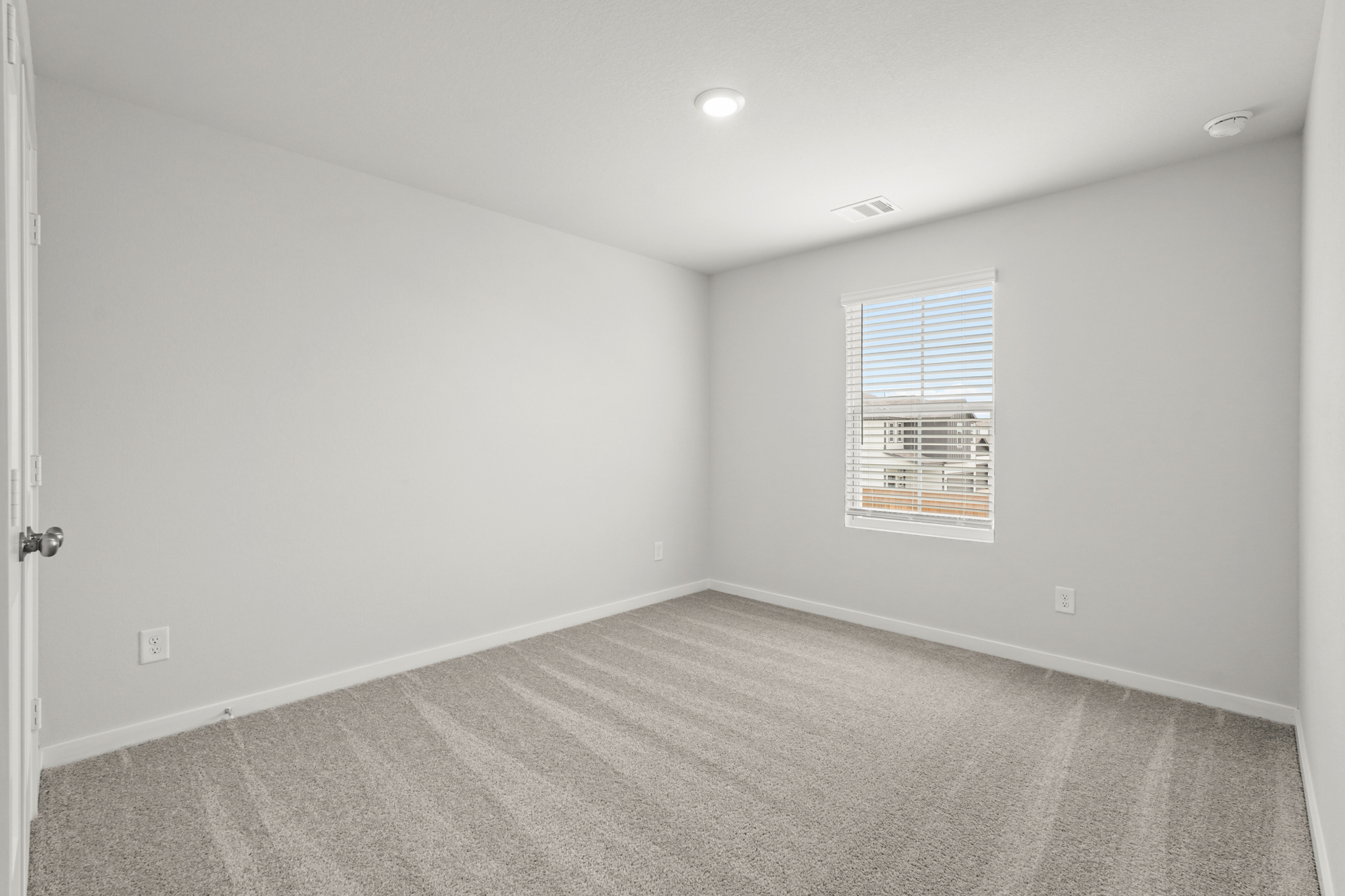 A room with a window and a carpet.
