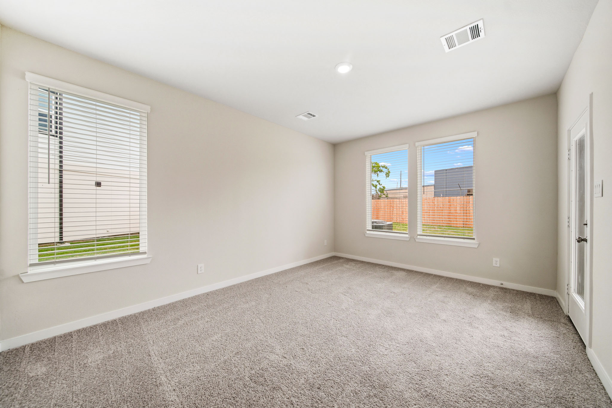 A room with a carpet and windows.