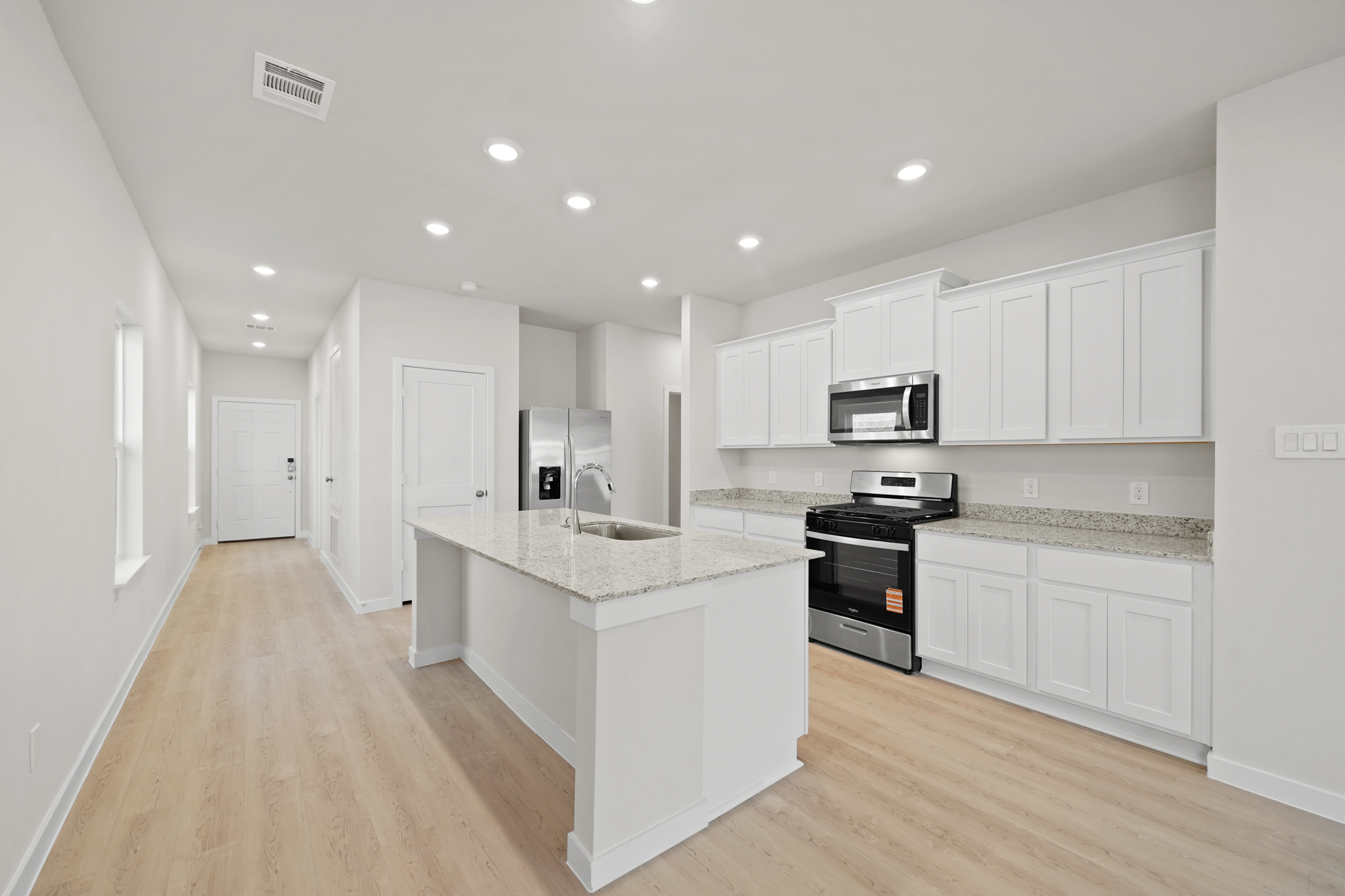 A kitchen with white cabinets.