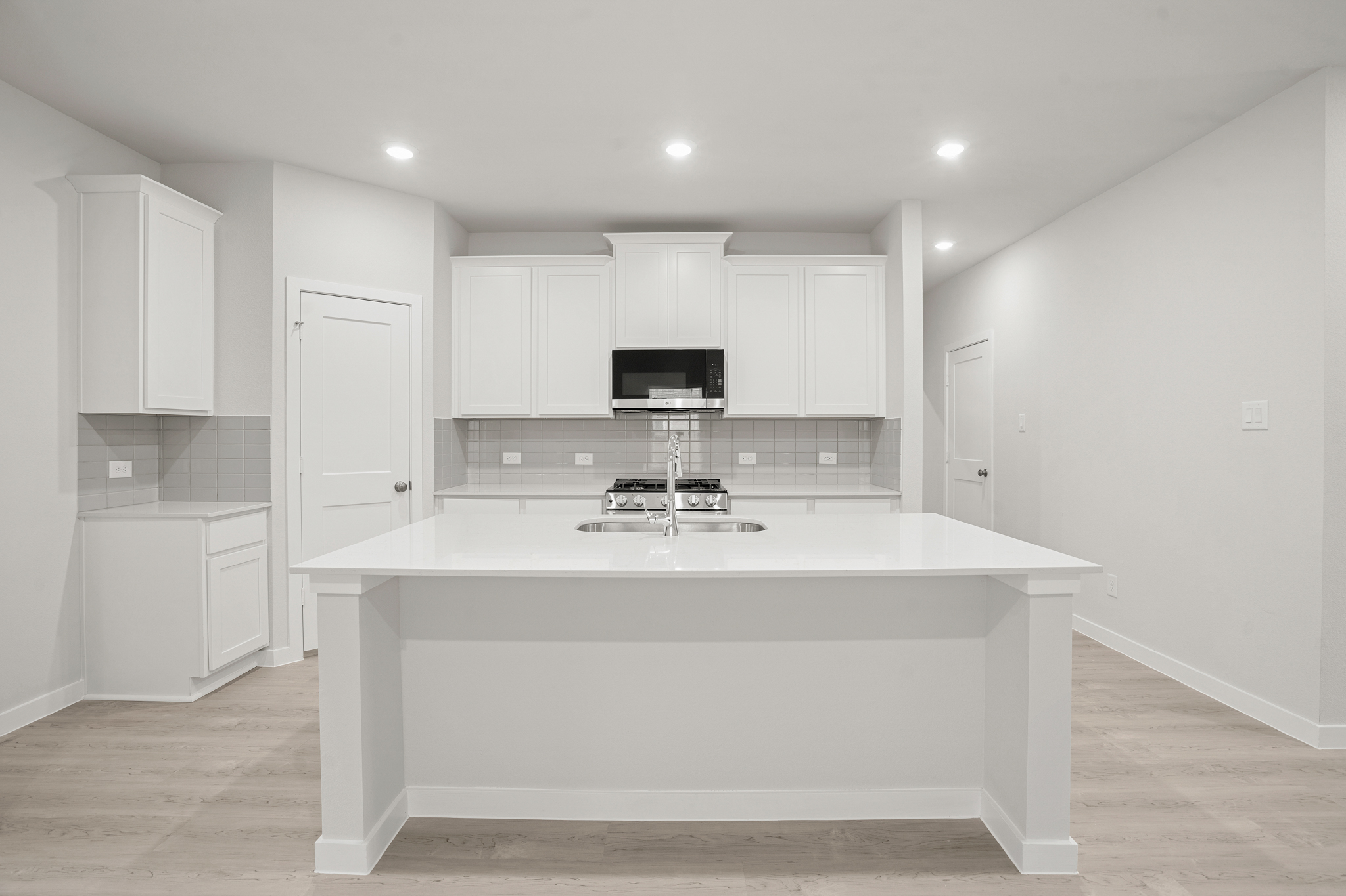 A kitchen with white cabinets.