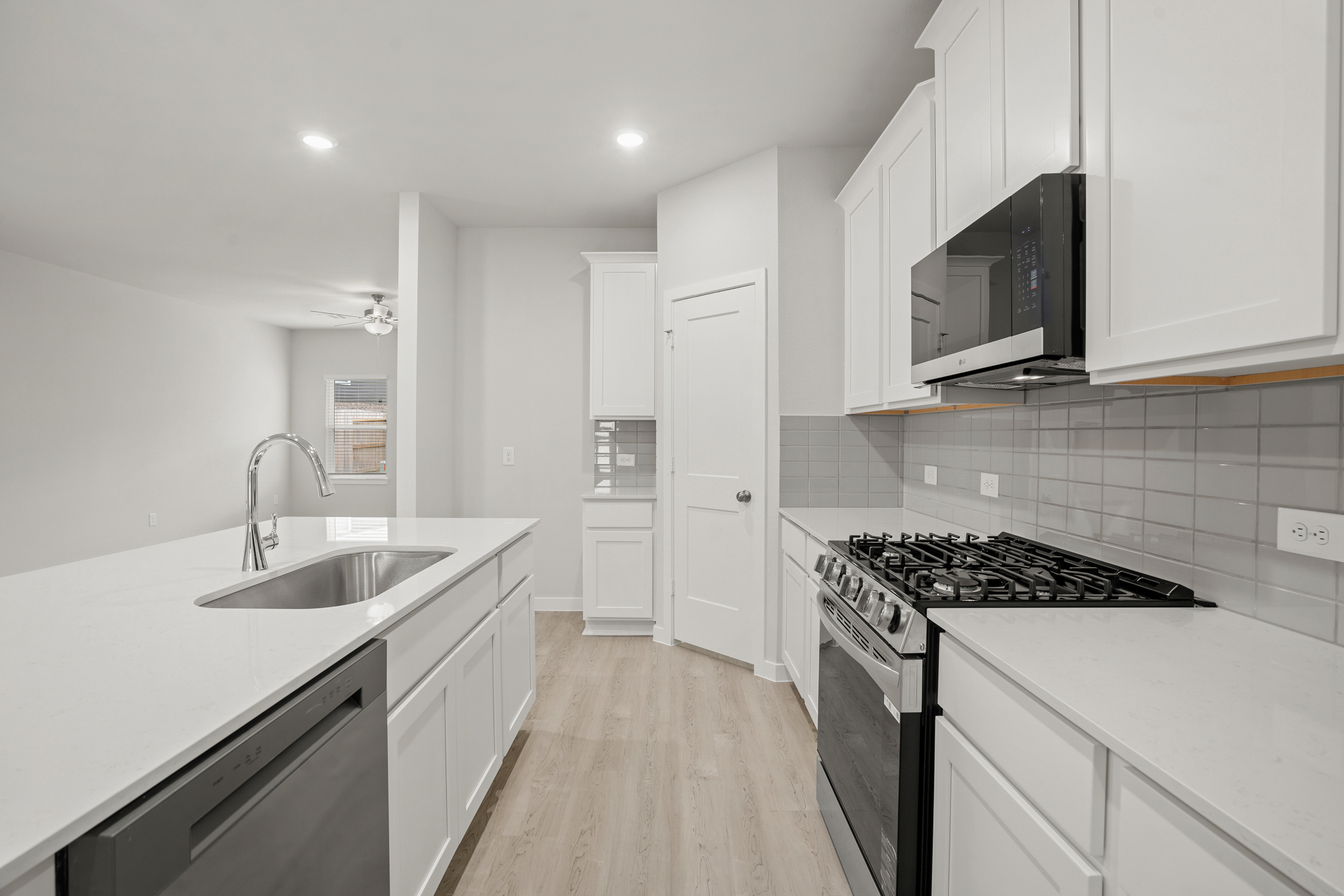 A kitchen with white cabinets.