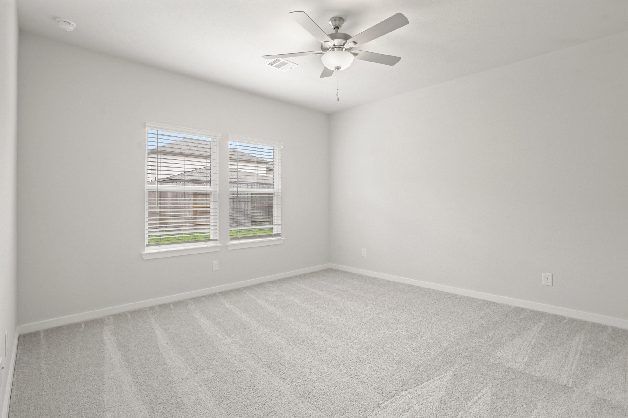 A room with a ceiling fan and a window.