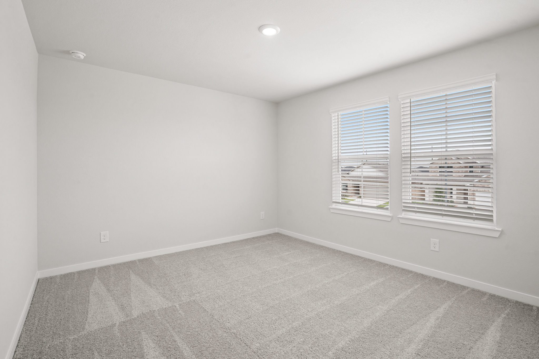 A room with a window and a carpet.