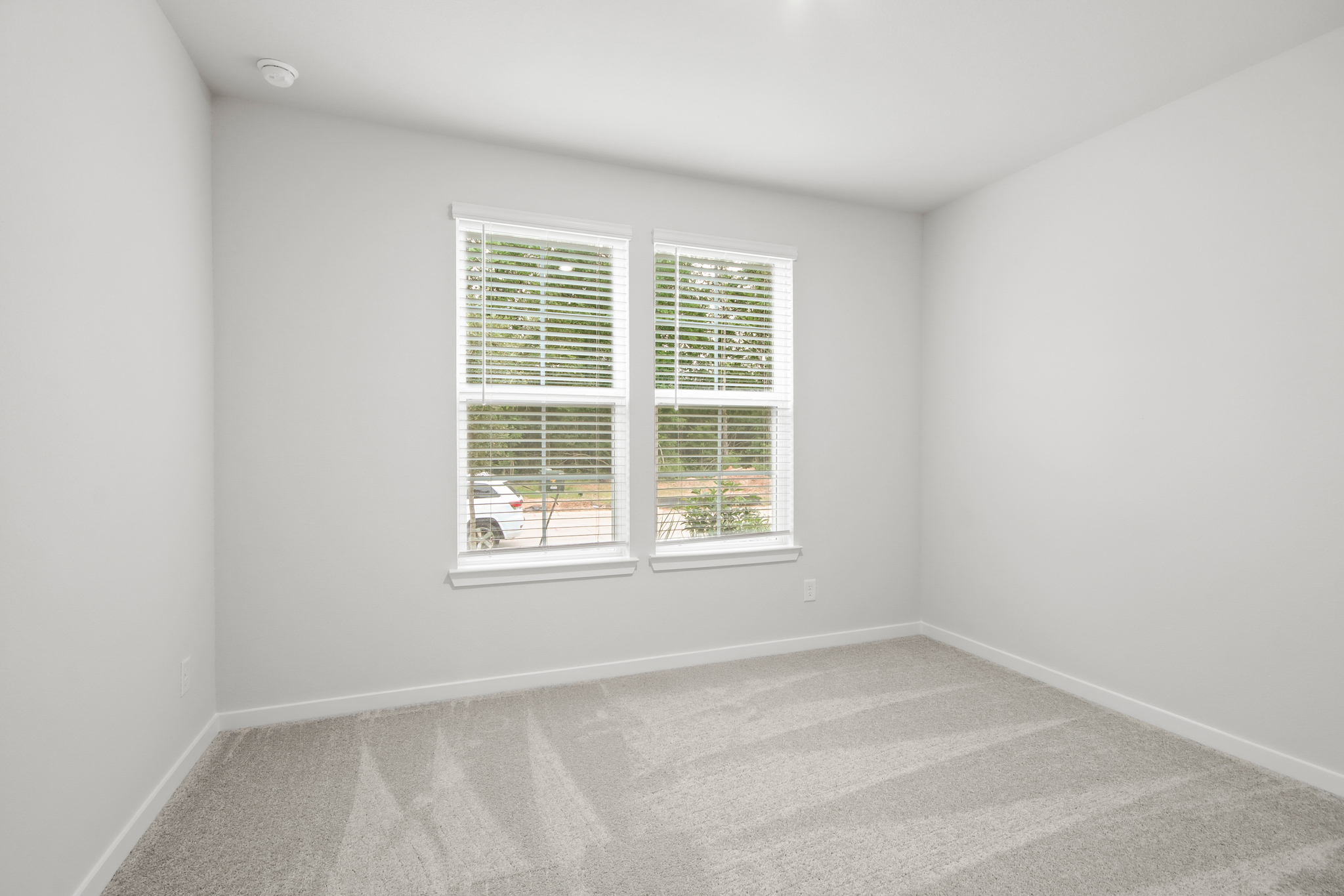A room with a window and a carpet.