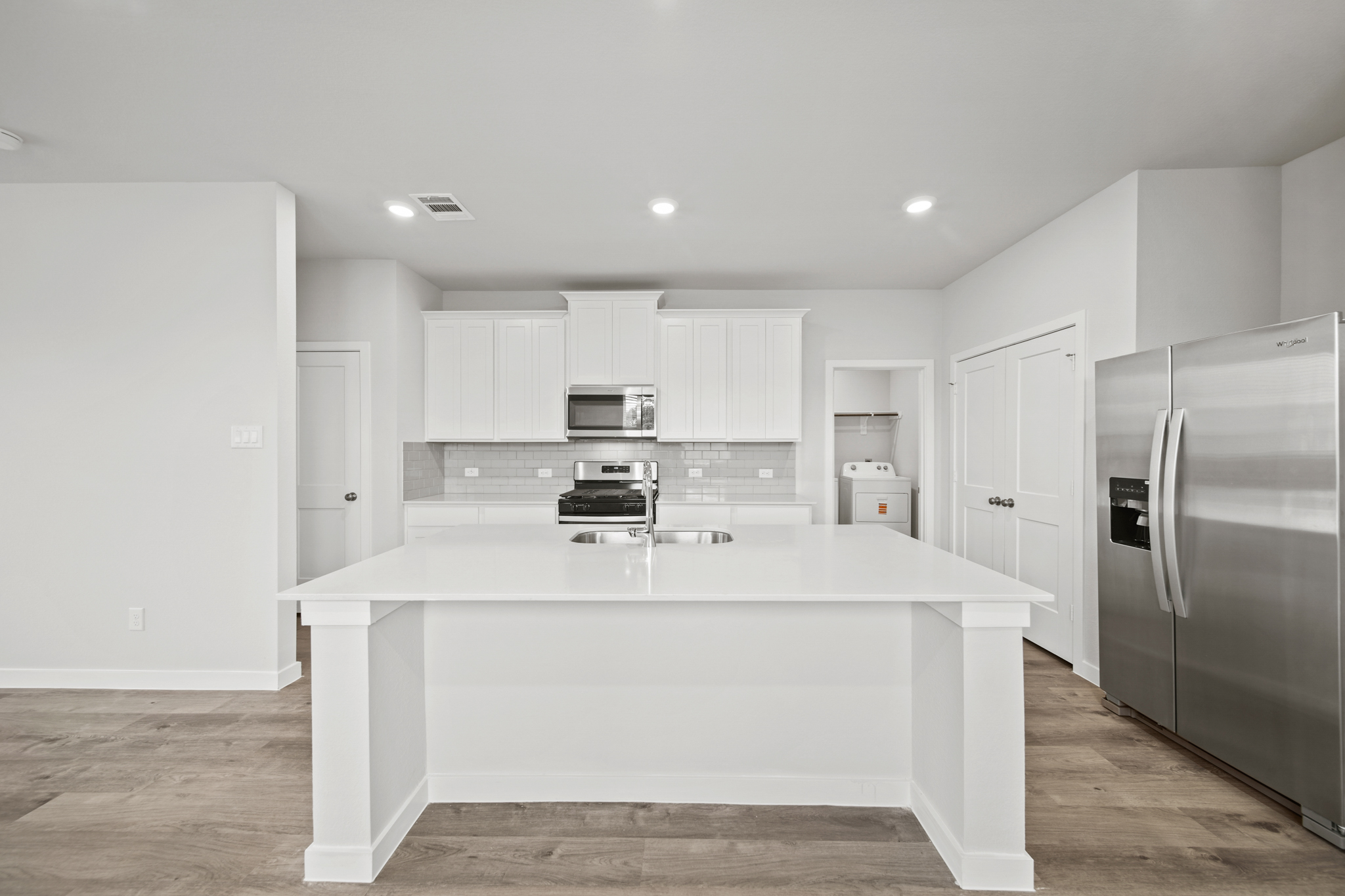 A kitchen with white cabinets.