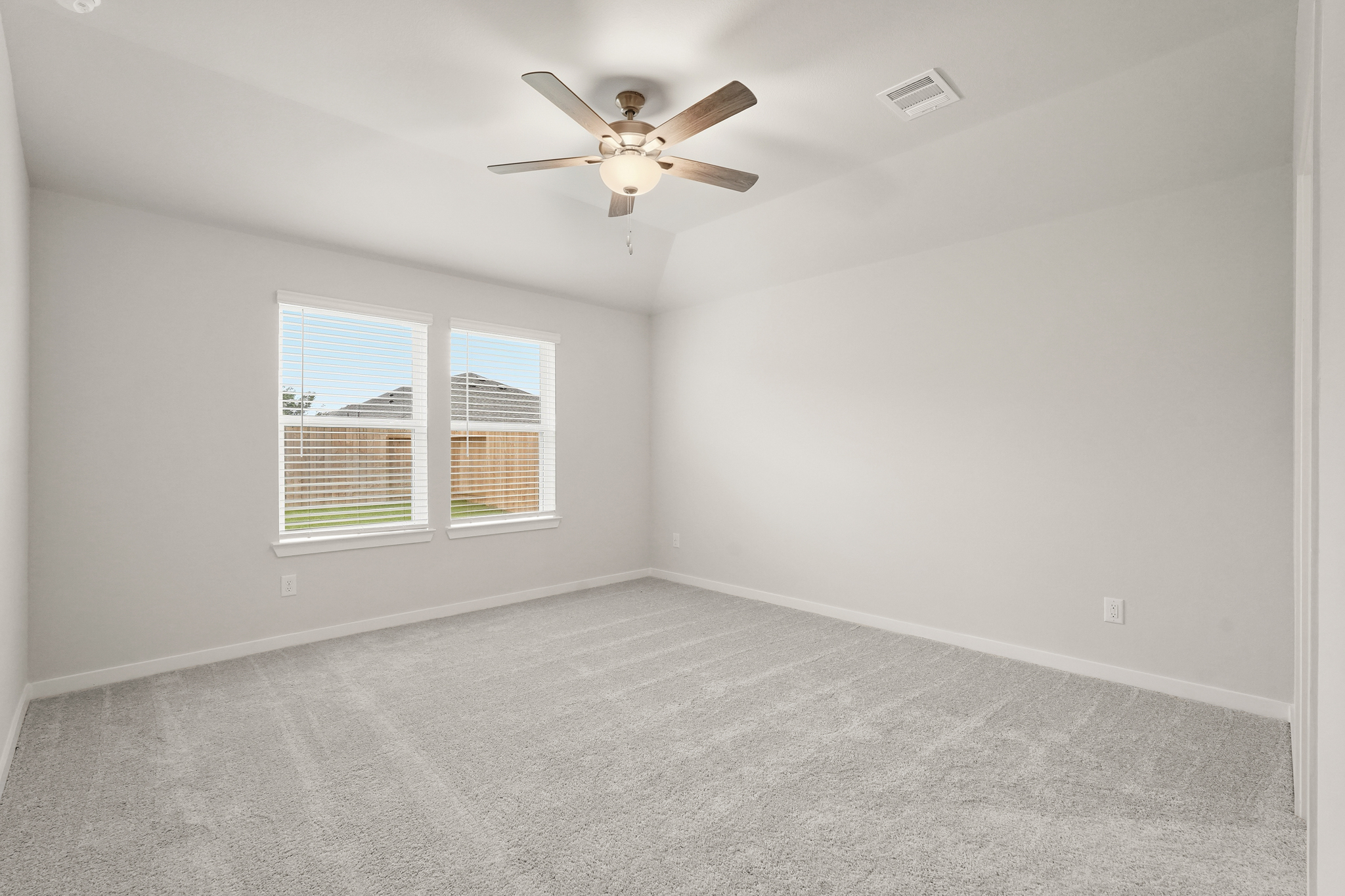 A room with a ceiling fan and a window.