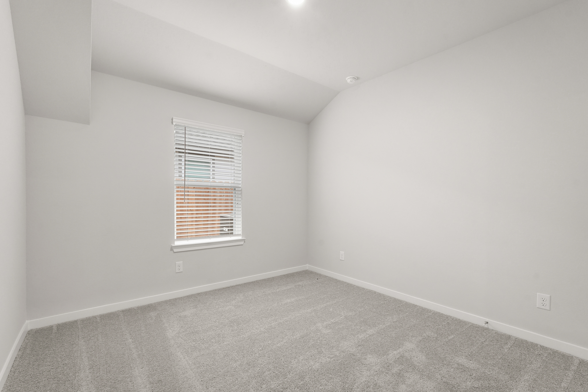 A room with a window and a carpet.