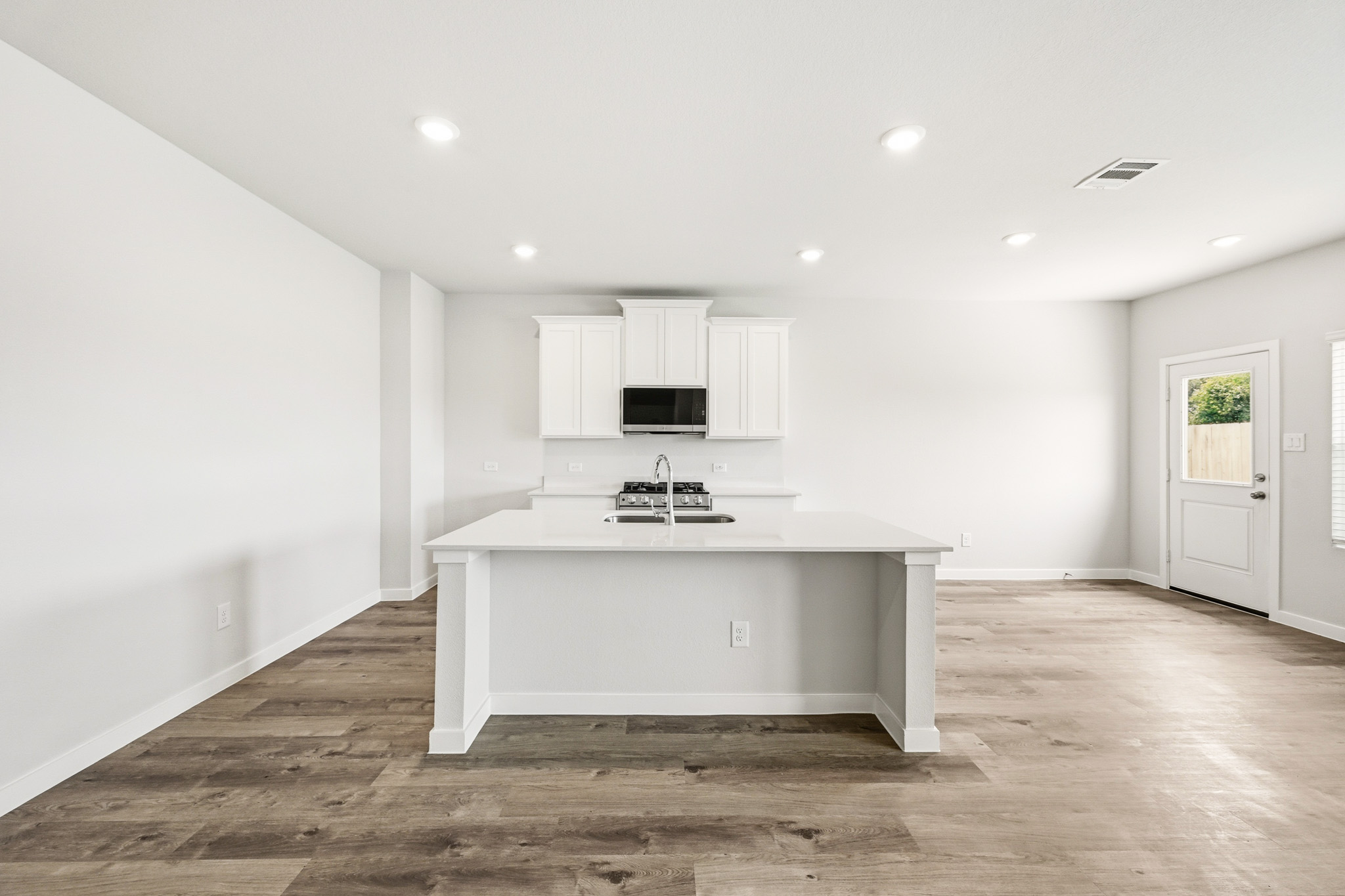 A large white kitchen with a white counter top.