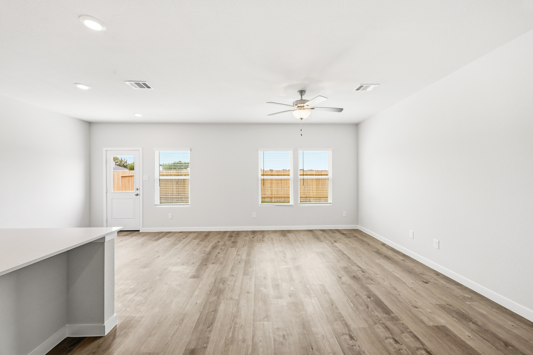 A room with a wood floor and a ceiling fan.