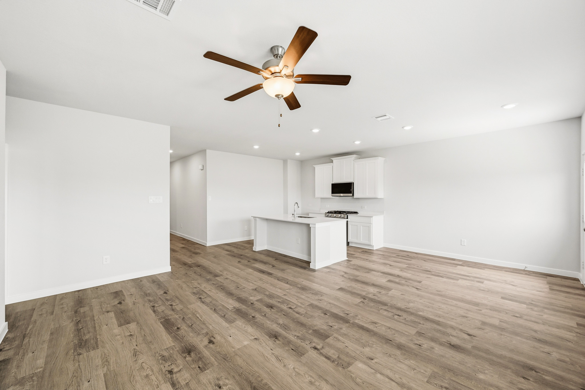 A room with a wood floor and a ceiling fan.