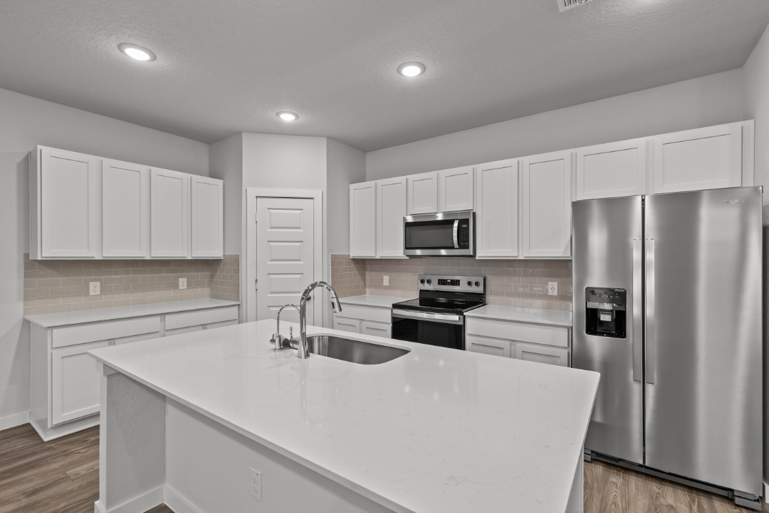 A kitchen with white cabinets.