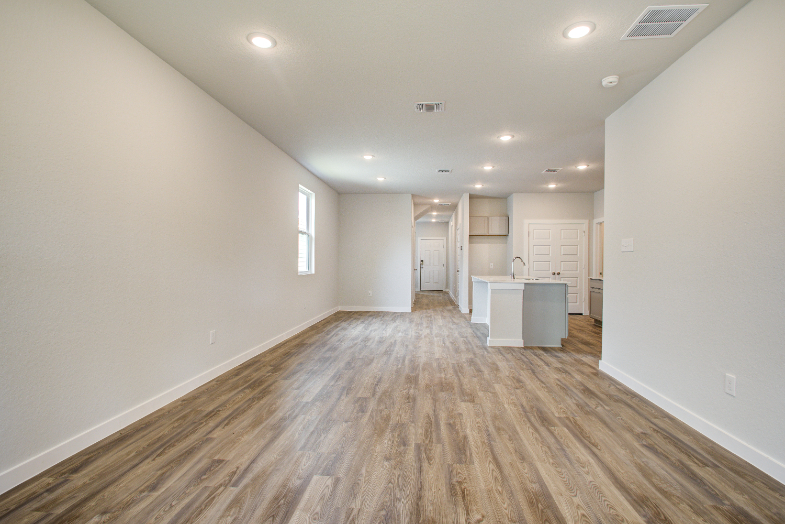 A room with white walls and wood floors.