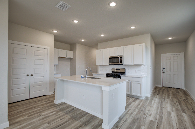 A kitchen with white cabinets.