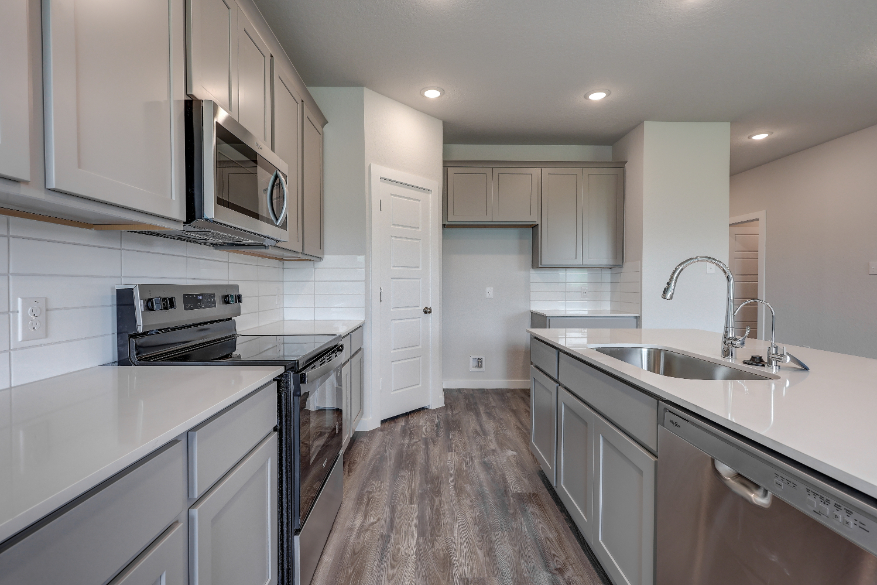 A kitchen with white cabinets.