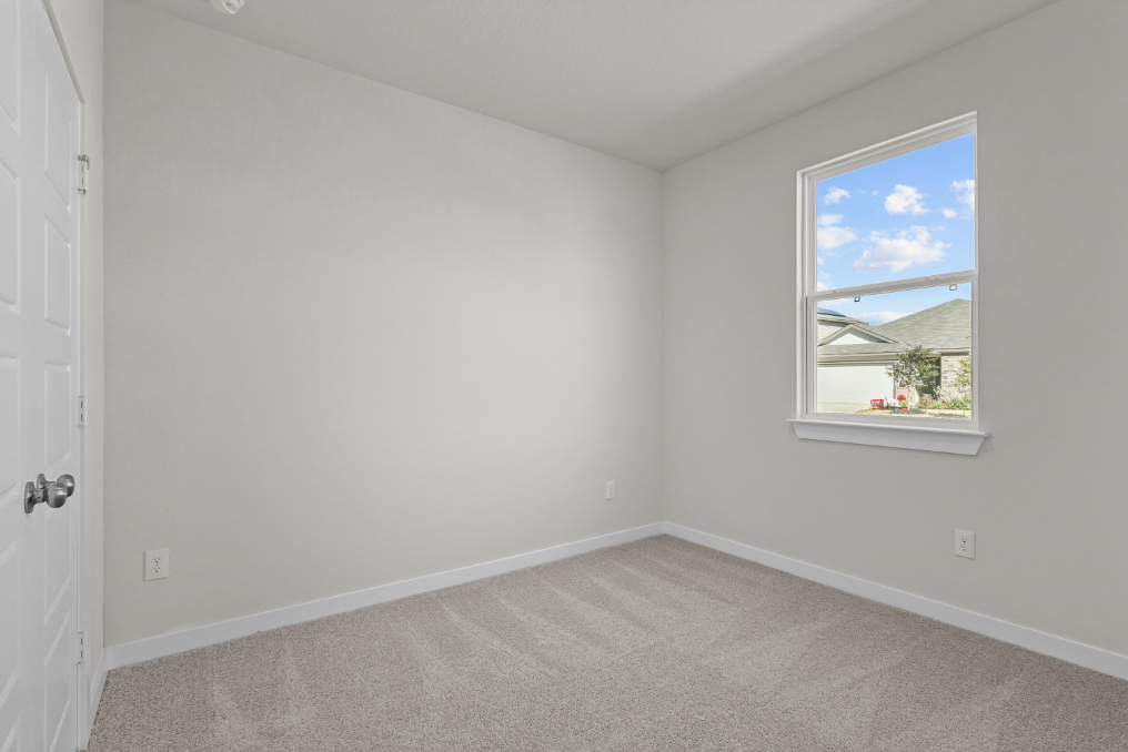 A room with a window and a carpet.