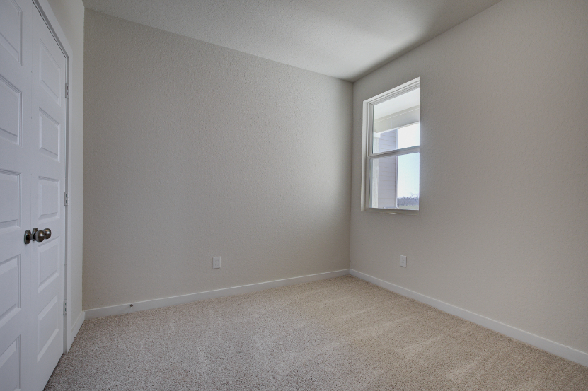 A room with a window and a carpet.