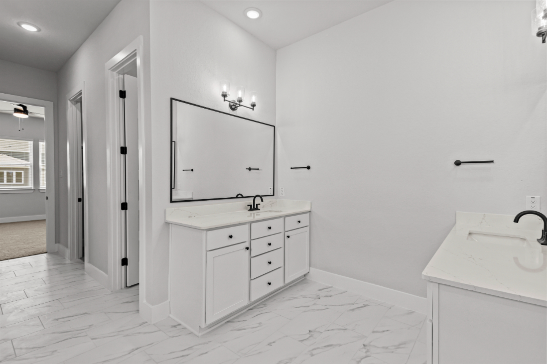 A bathroom with white cabinets.