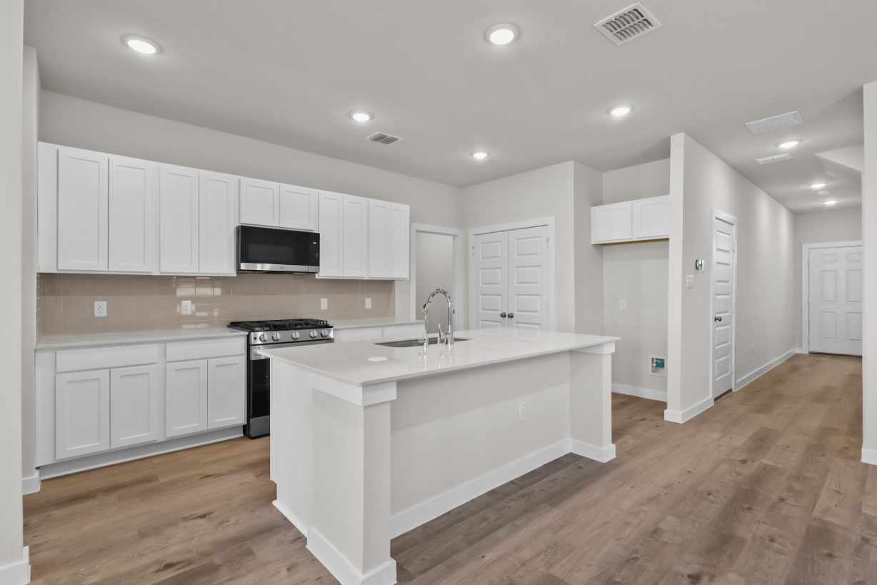 A kitchen with white cabinets.