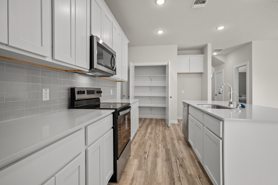 A kitchen with white cabinets.