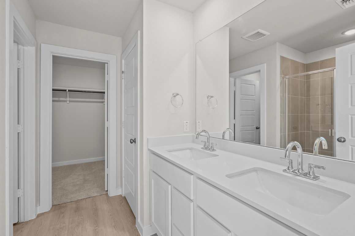 A bathroom with white cabinets.