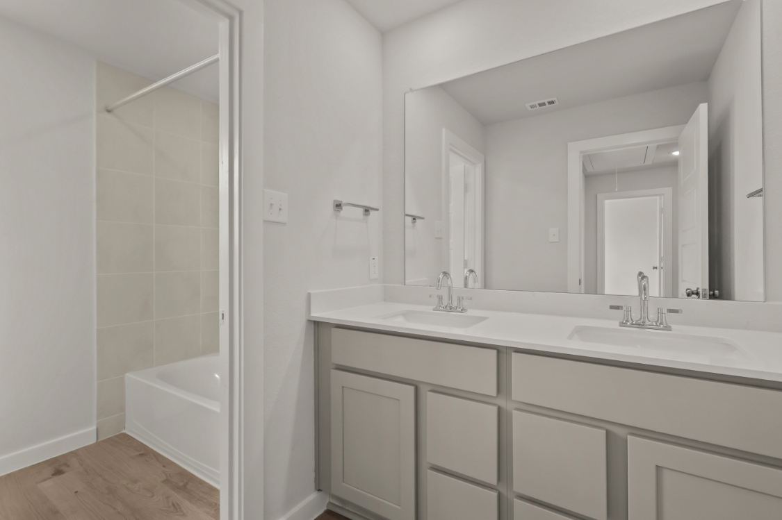 A bathroom with a sink and a shower.