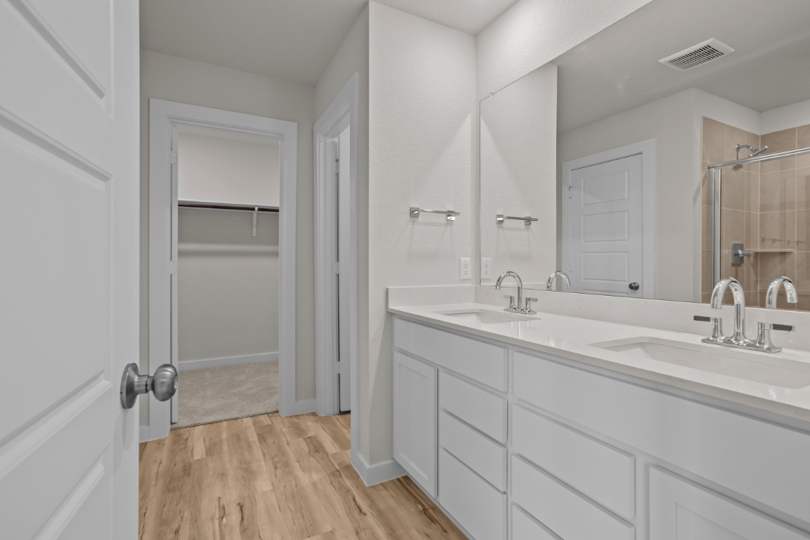 A bathroom with white cabinets.