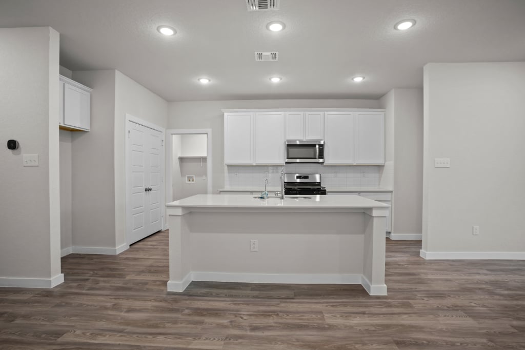 A kitchen with white cabinets.