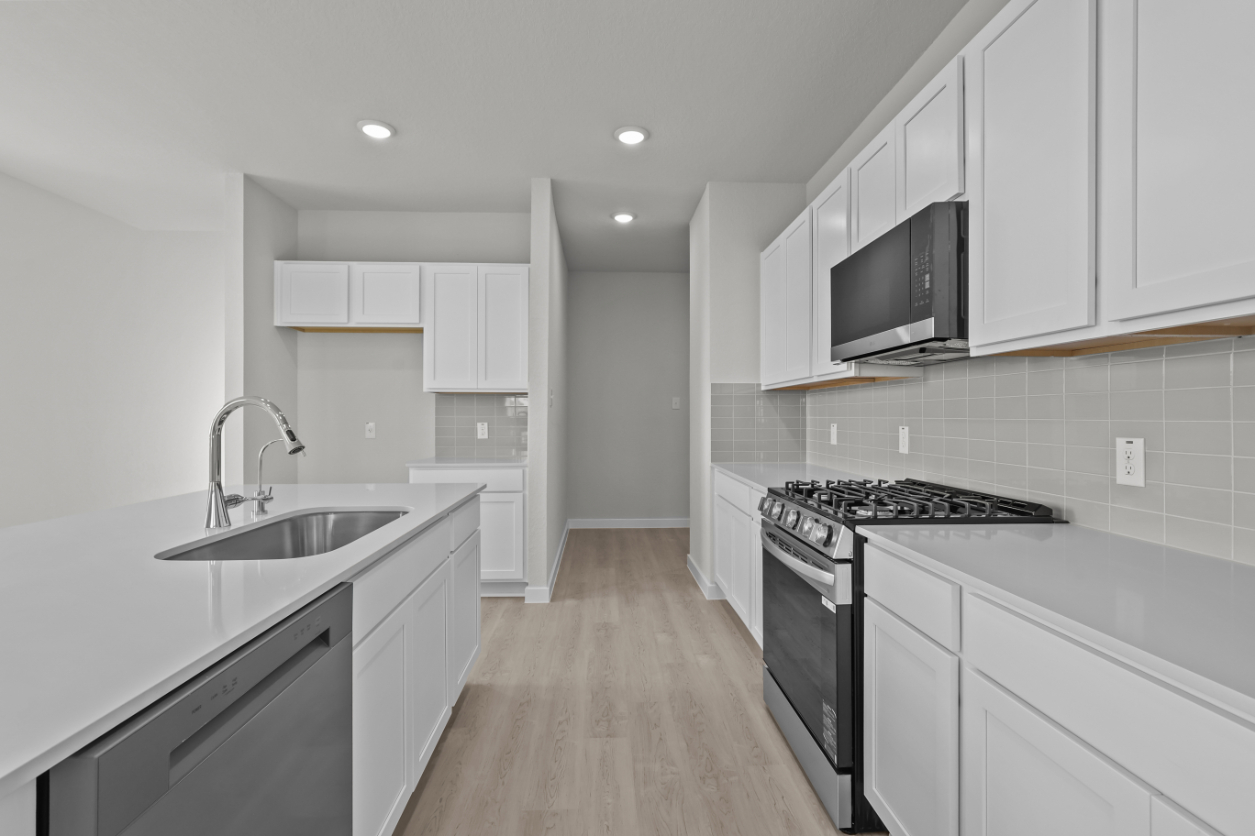 A kitchen with white cabinets.
