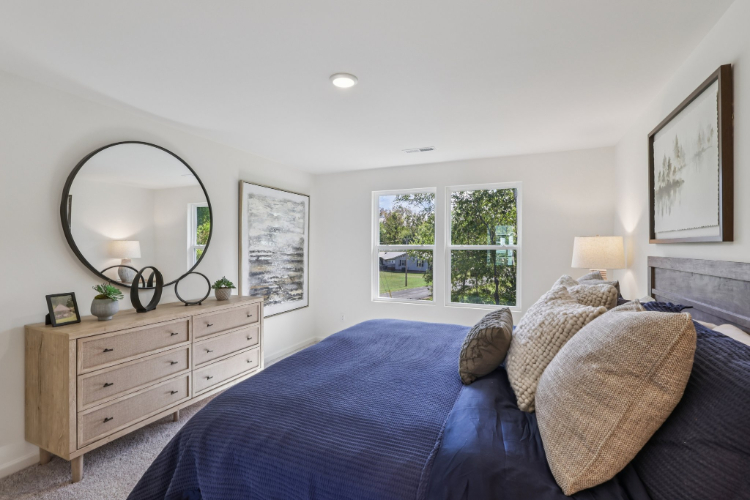 A bedroom with a bed and a mirror.